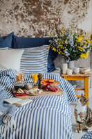 Misty Edge Påslakan 150x210 i färgen Denim Blue på enkelsäng med frukostbricka