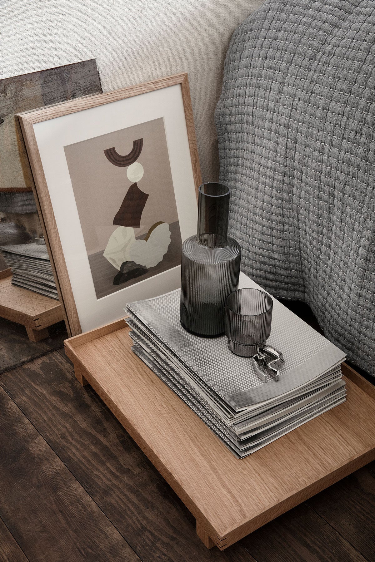 Ripple Karaff i färgen Smoked Grey på sängbord bredvid en säng