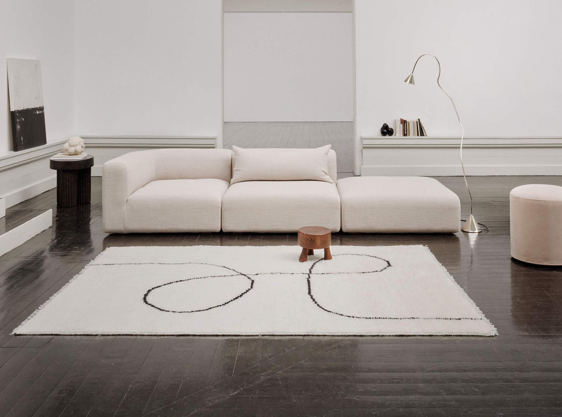 Linie-Design_Astral-Spiral-svart-miljo-1.jpg Astral matta i ett ljust vardagsrum med soffa och lampa