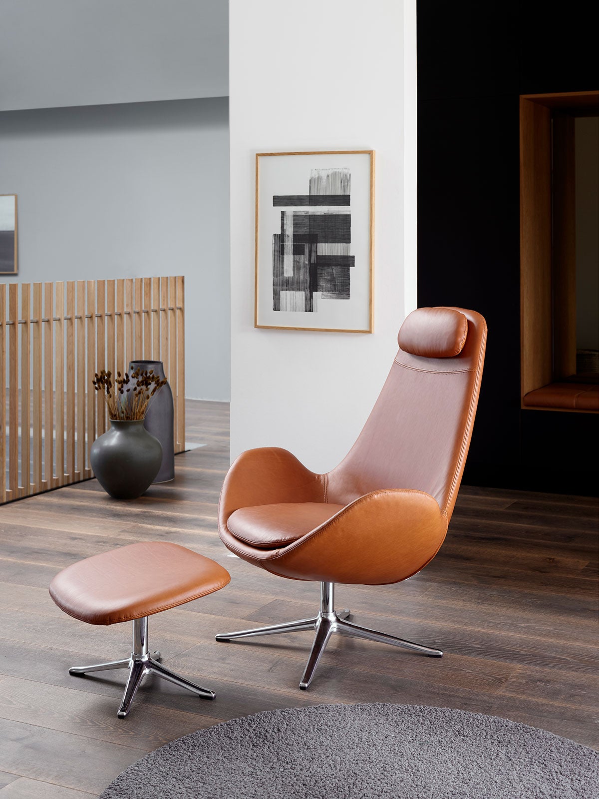 Ghost High Fåtölj med fotpall i lädret Nature Cognac med ben i polerad aluminium i ljust vardagsrum