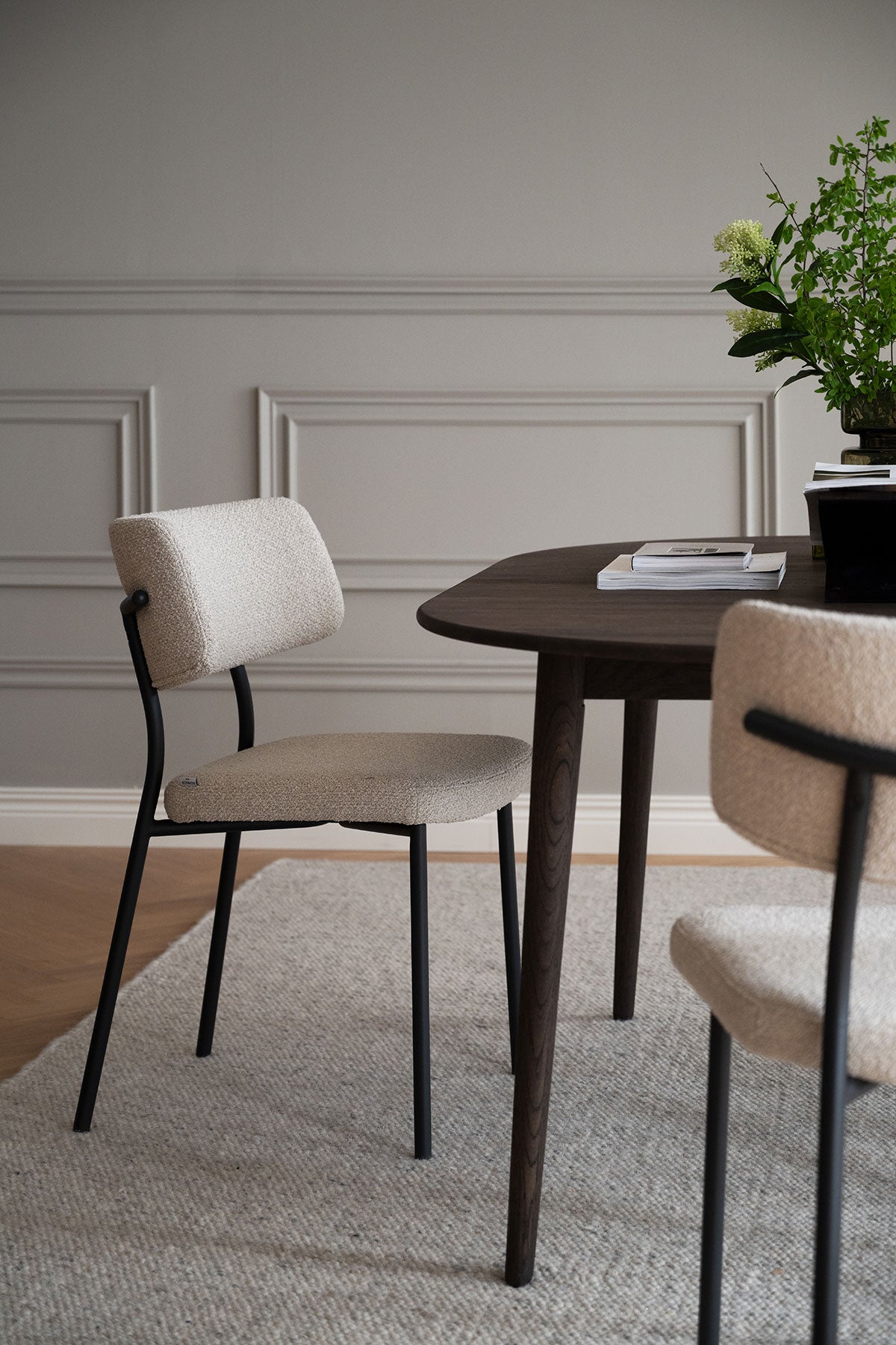 Herbster Stol i beige tyg med svarta metallben vid ett brunt matbord i matsal