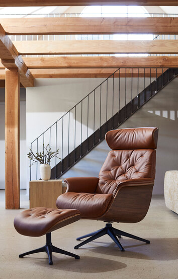 Volden Fåtölj och fotpall i lädret Modern Cognac Brown med ben i svart aluminium i vardagsrum med ljusinsläpp