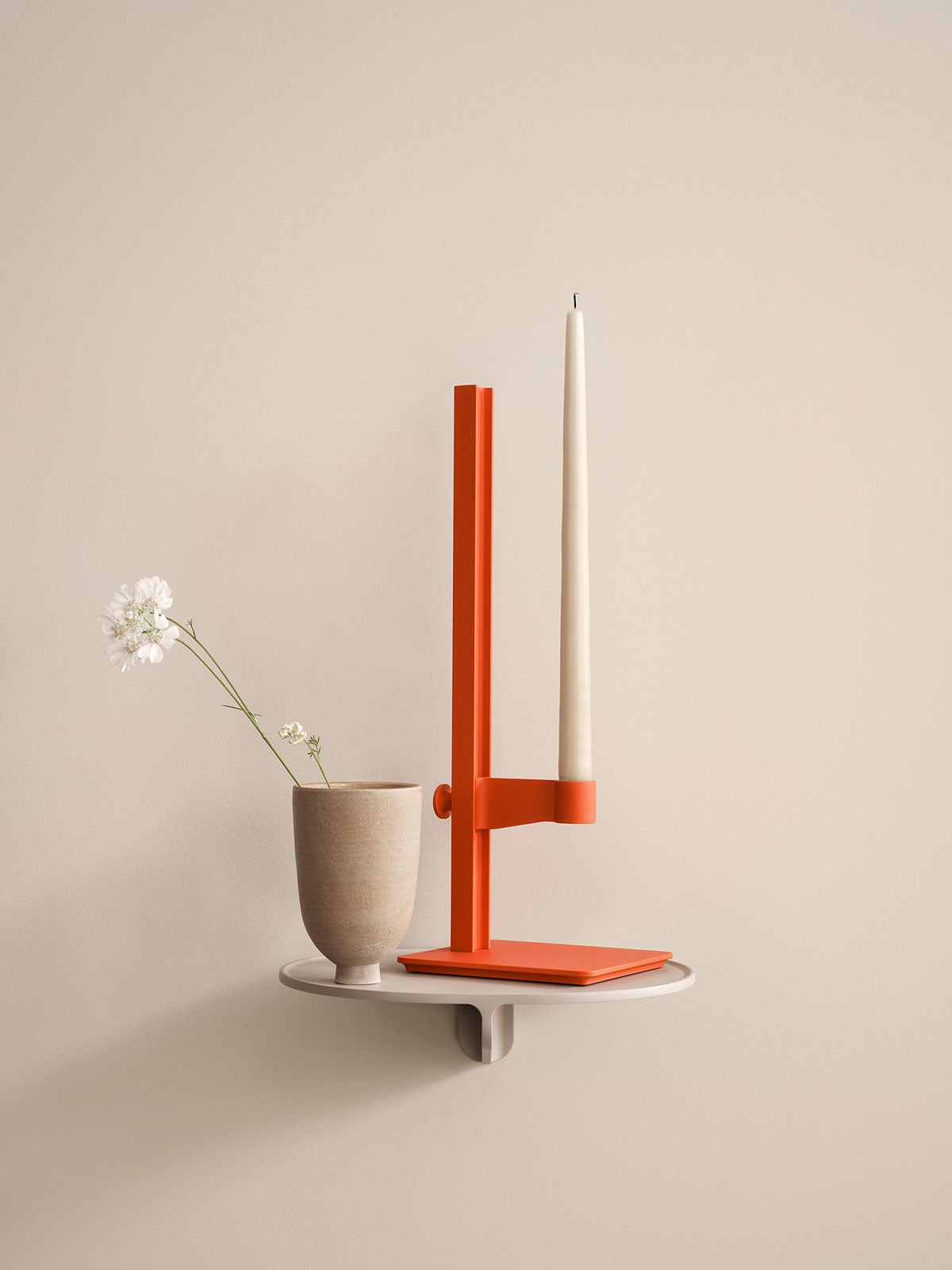 String Museum Ljusstake Orange på beige vägghylla med vas