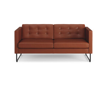 Bilden visar Madison, i tvåsitsig modell. Soffan är klädd i lädret Elmosoft 33001, med knappar i ryggen. Medstativet är i svart utförande.