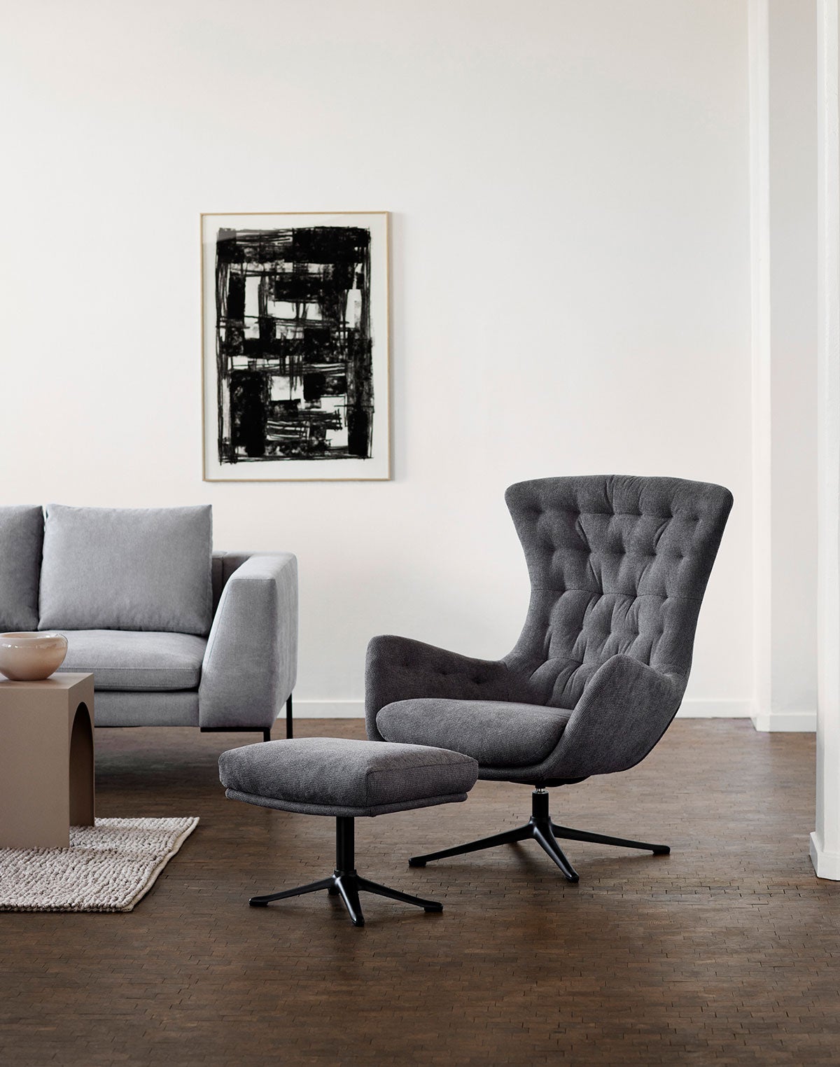 Sini Fåtölj och fotpall i tyget Bellaria Thunder Grey med ben i svart aluminium i modernt vardagsrum