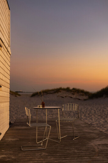 High Tech Stol Varmförzinkad runt High Tech Bord 60 i solnedgång på sandstrand
