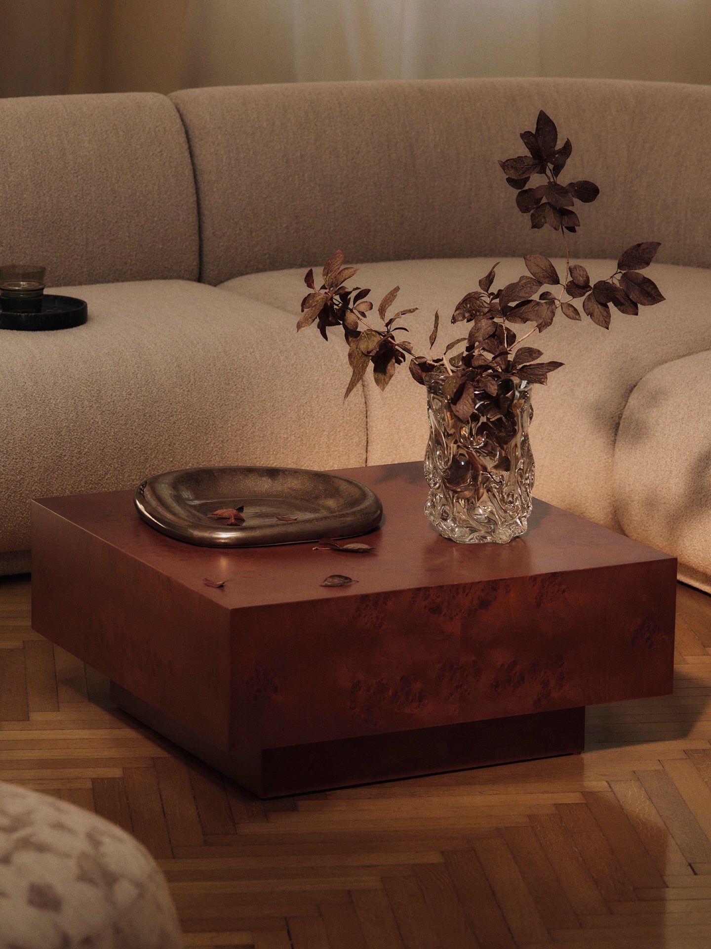 FermLiving_AW25_BurlStorageCoffeeTable_DarkStainedBurl_1104272383_BellureCentrepiece_35_RusticBronze_1104272110_VirelleVase_H24_Clear_1104272101_RicoCorner90SoftBouclé_Natural_1104272257_1104272573_1104272574