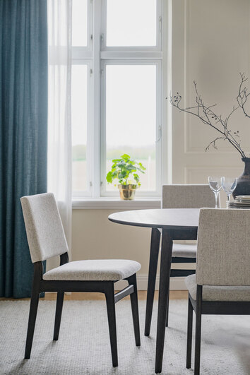 Medford Stol i brun ek med ljusbeige tyg vid ett runt bord i matsal