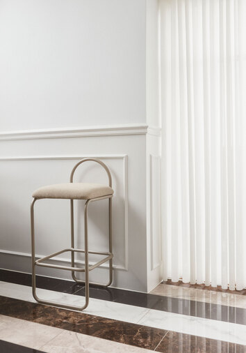 Angui Barstol Taupe Bouclé intill ett fönster med vita gardiner