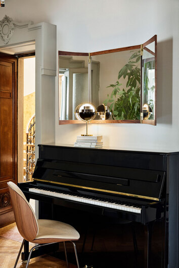 Vanity Väggspegel 3 ovanför piano med bordslampa i krom