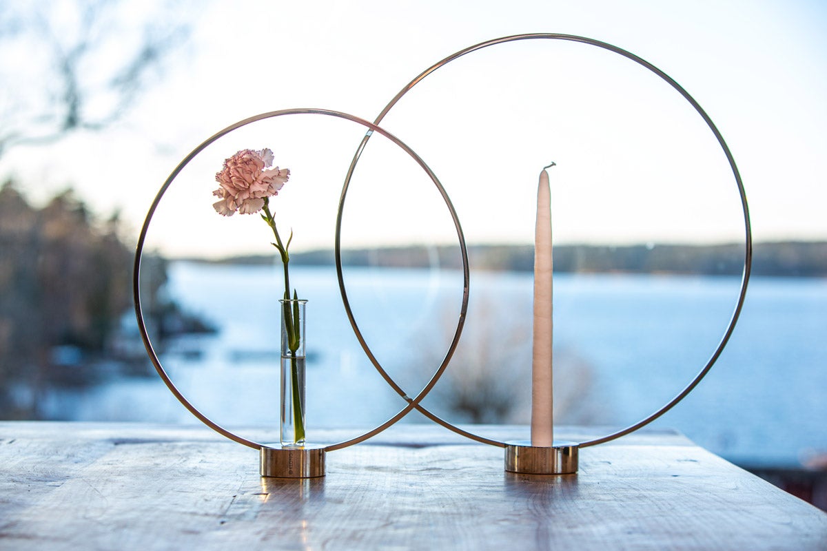 Gloria Ljusstake Nickel i stor och liten storlek med blomma och ljus vid havsutsikt