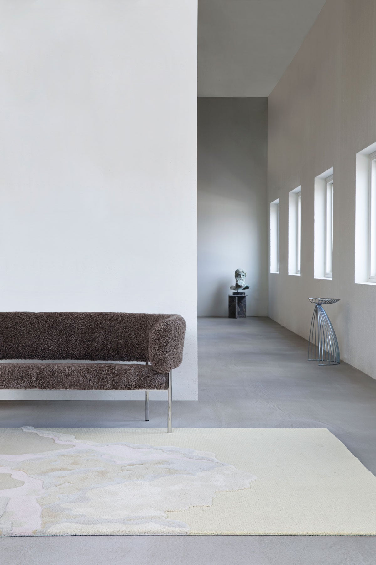 Cloud9 Matta Afternoon framför en soffa i mörkt tyg