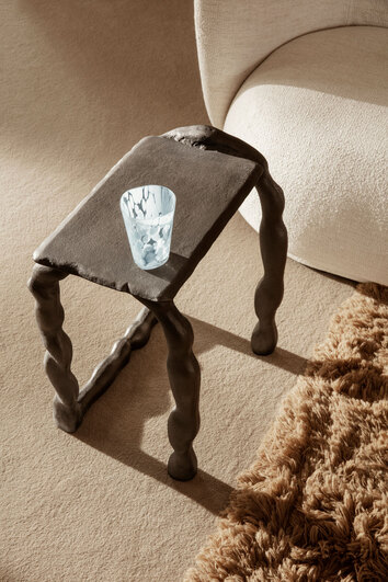 Rotben Skulptur som sidobord intill fåtölj