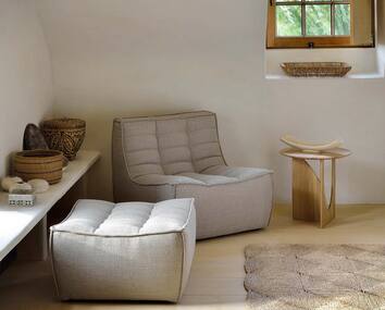 N701 Fåtölj och fotpall i beige tyg i naturlig miljö