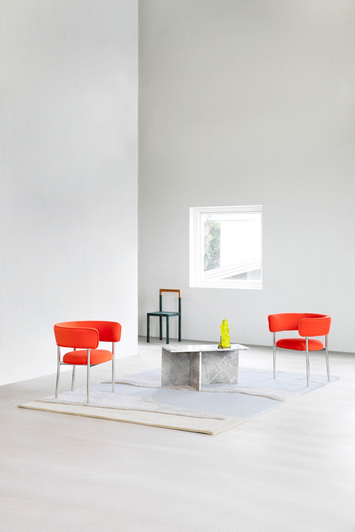 Cloud9 Matta Morning i högt rum med soffbord i sten, två röda fåtöljer och en svart stol vid ett fönster