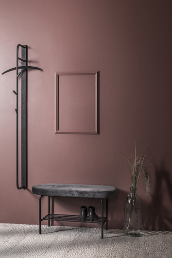 Town Hallbänk i mörkröd hall med ett par skor bredvid en klädhängare och en vas