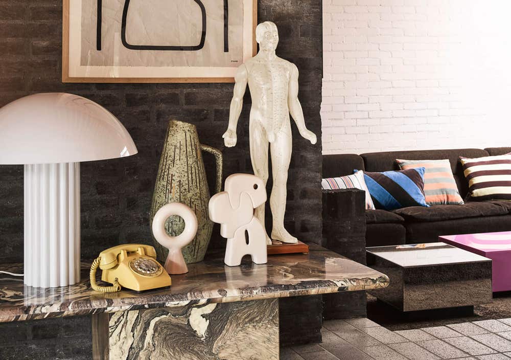 Cupola-Bordslampa-HKliving.jpg Coupola bordslampa ståendes på ett avställningsbord med massor av andra prylar