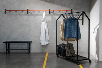 Clothing House Klädställning i svart stål i industriell miljö