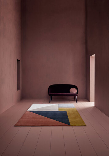 Arguto Matta Multi i smalt rum med en soffa i mörk färg