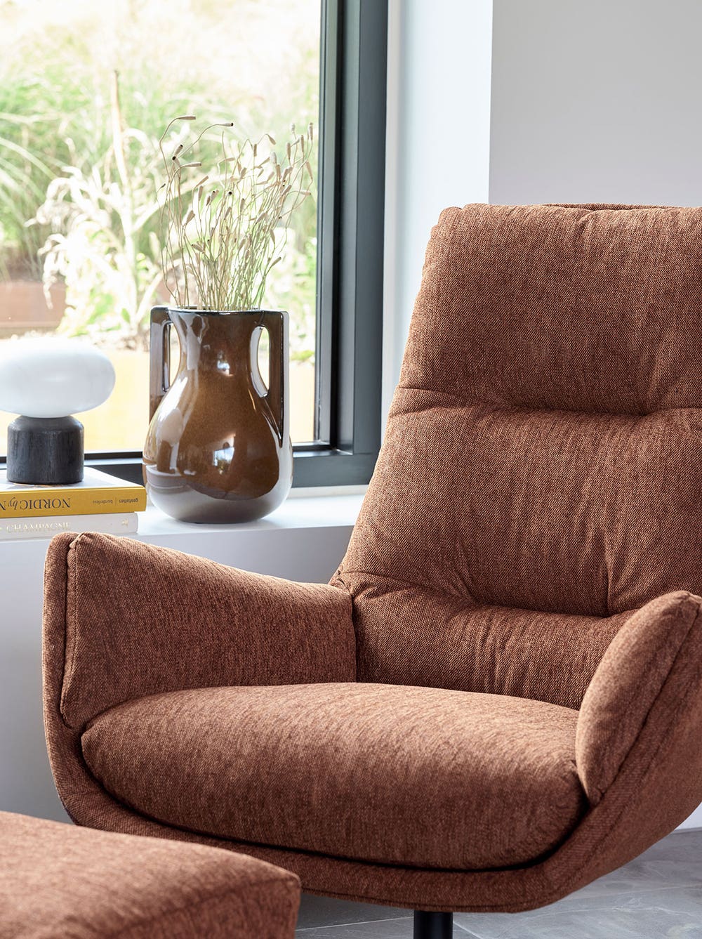 Flexlux-Moro-Design-Chair-Footstool-Copparo-Rusty-Orange-Lifestyle-1.jpg Moro Fåtölj i tyget Copparo Rusty Orange framför ett fönster