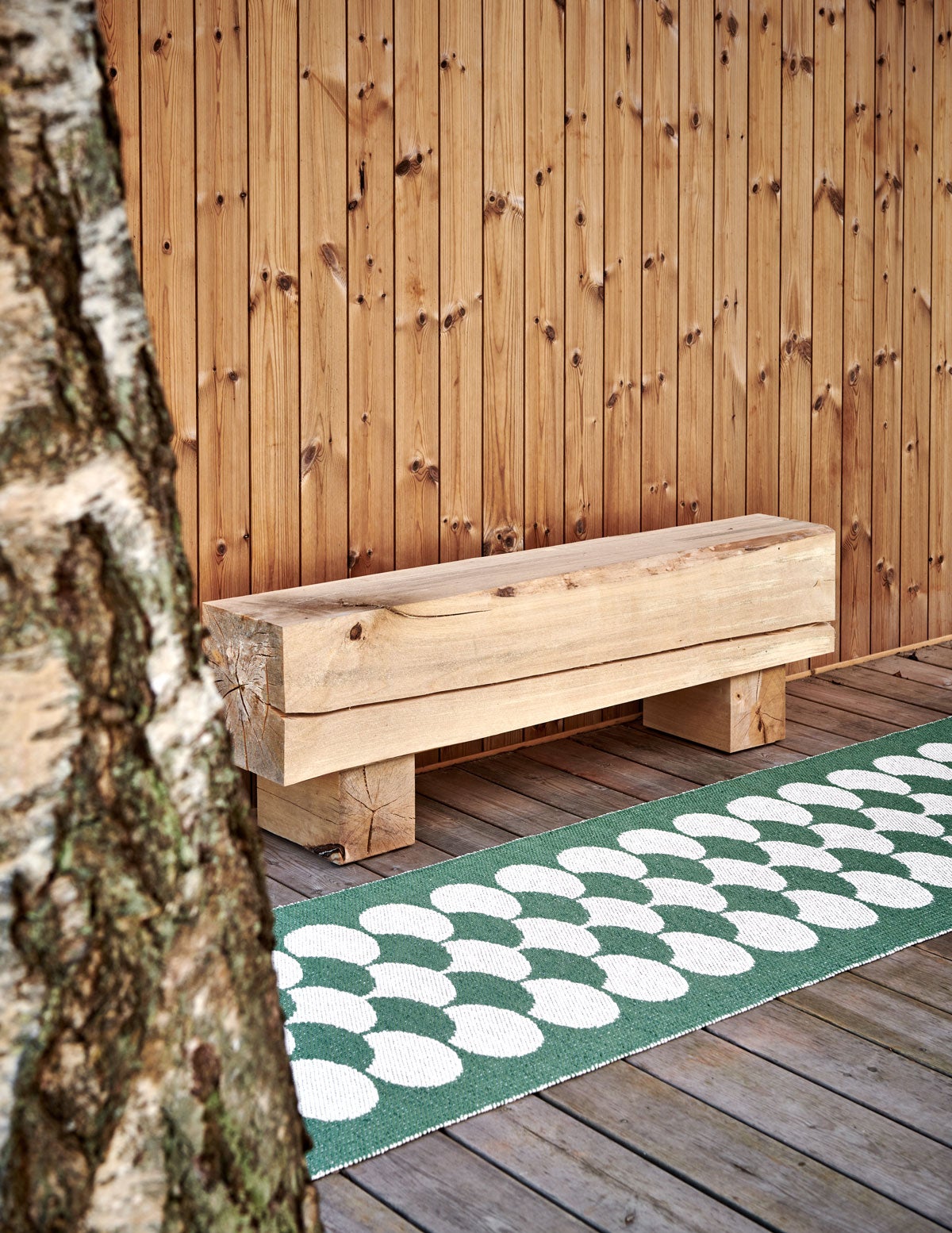 Poppy Gångmatta Oregano vid en uteplats på ett modernt trähus.