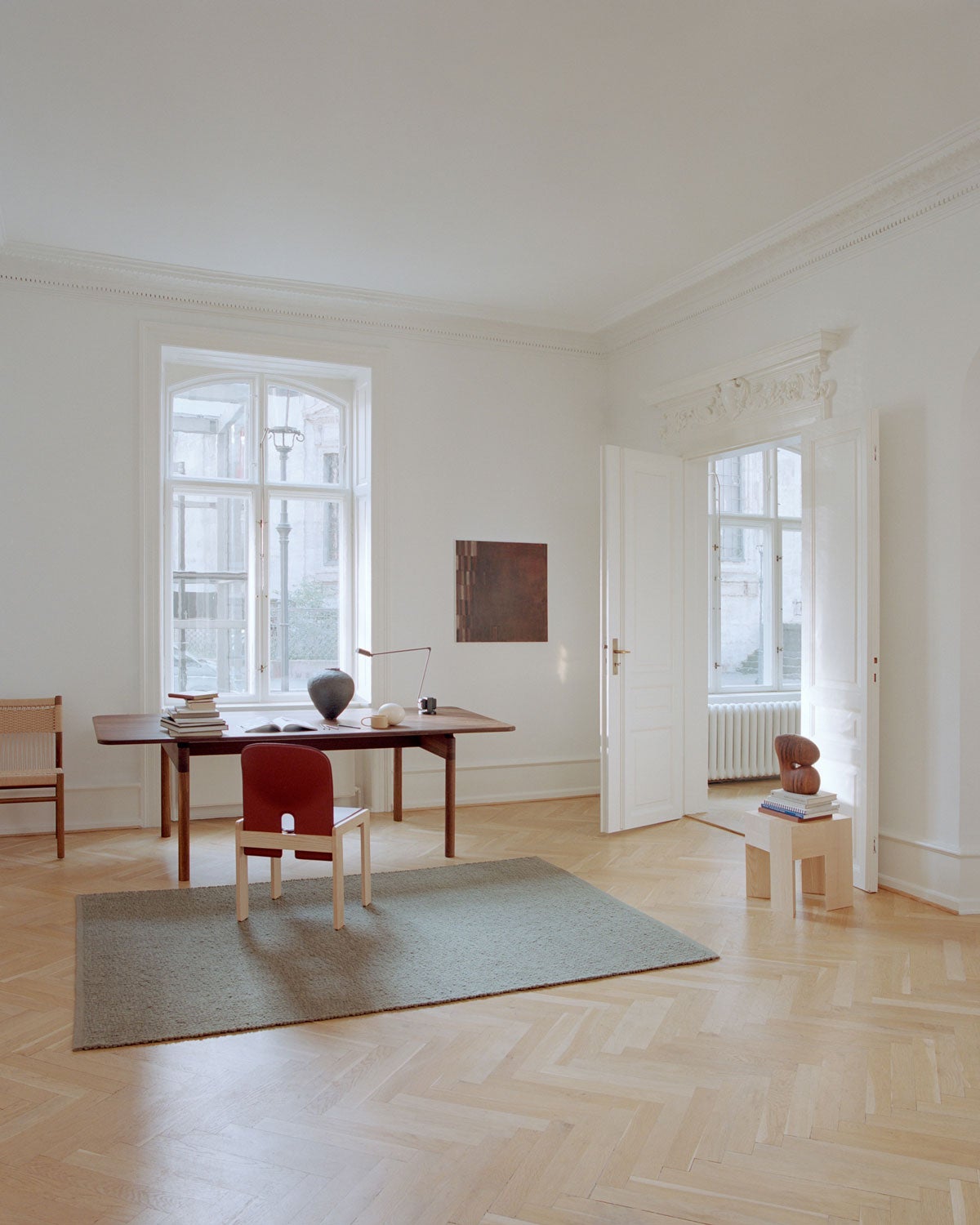 Pebbled Poem Matta i färgen Moss under ett skrivbord i ett ljust, öppet rum