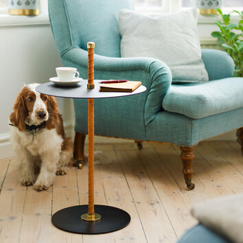 Cabaret Sidobord i färgen Svart bredvid en turkos fåtölj