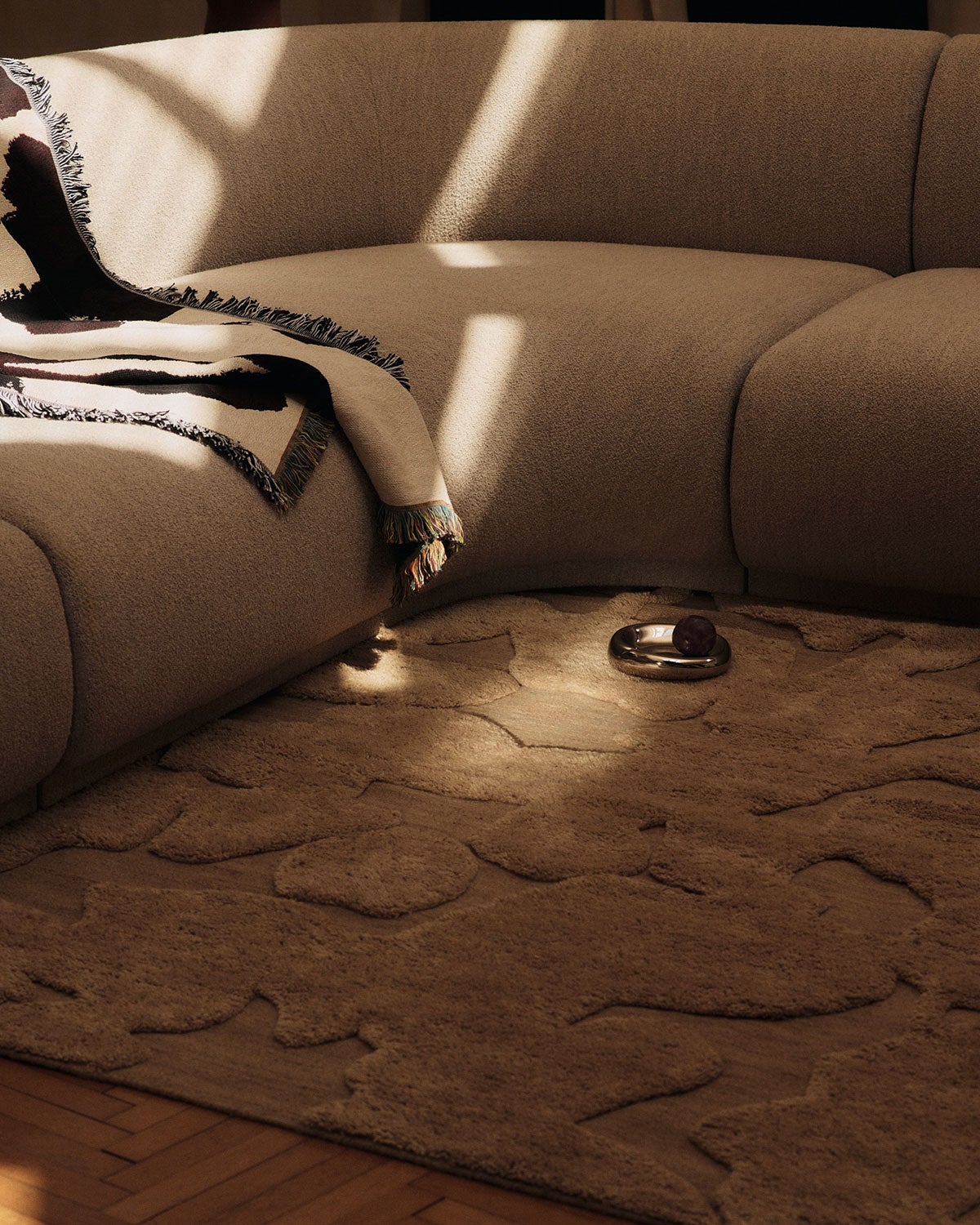 Cilla Matta i färgen Tan under en beige hörnsoffa