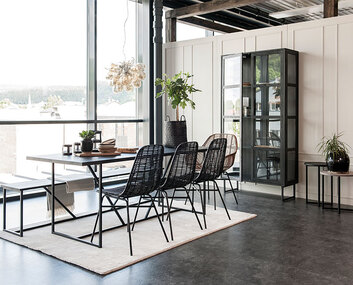 Zet Vitrinskåp i ett ljust rum med mörka matsalsmöbler