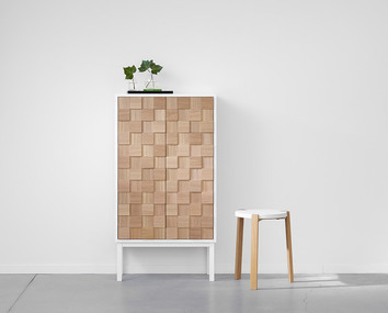 Collect 2016 Skåp Högt Vitpigmenterad Ek med två vaser med löv bredvid en pall