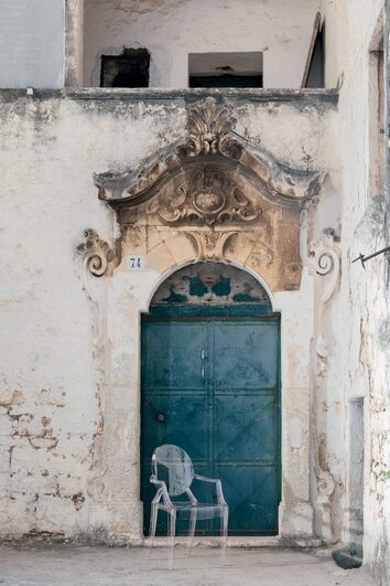 Louis Ghost Stol Crystal framför dörröppning till äldre byggnad