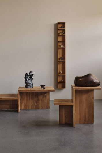 Distinct sidobord i ek tillsammans med Distinct soffbord i ek i rum med gråa väggar. 