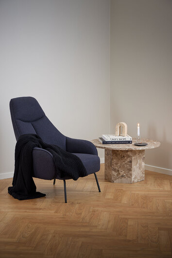 Actona Naxos lattebrunt soffbord med mörkblå fåtölj vid sidan.