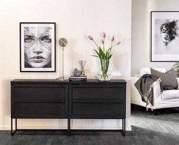 Everett Sideboard 160 i svart ek med en bordslampa, en vas med blommor och dekorativa detaljer