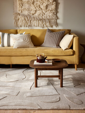 Vivid matta med en gul soffa i ett vardagsrum