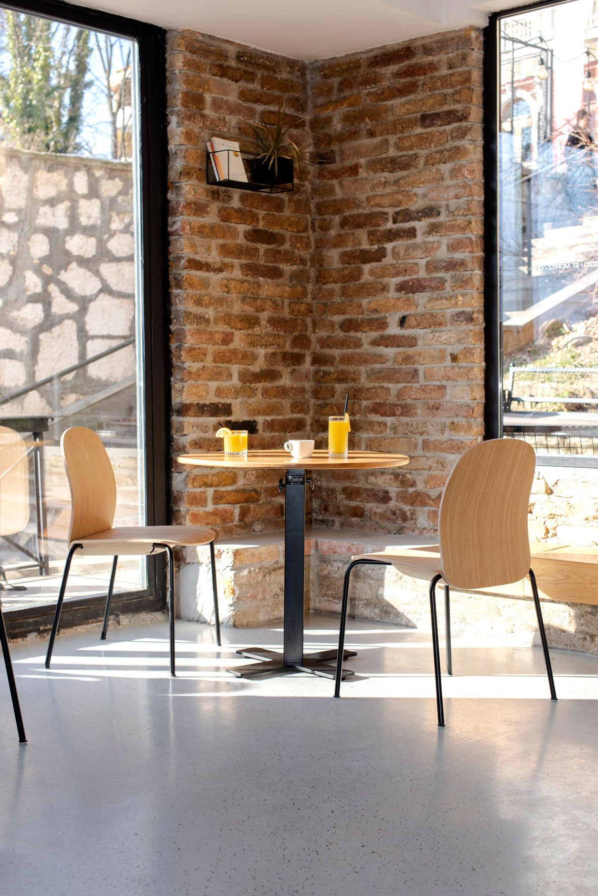 Två stycken Book Stol med träsits i naturlackad ek runt ett cafébord på restaurang