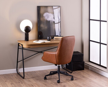 Erik skrivbordsstol i cognac framför skrivbord.