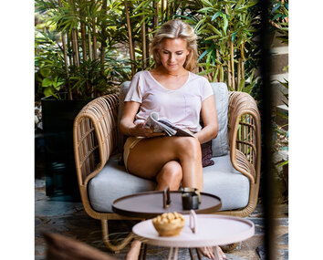 Nest Loungefåtölj Natur i utomhusmiljö med en kvinna som läser en tidning