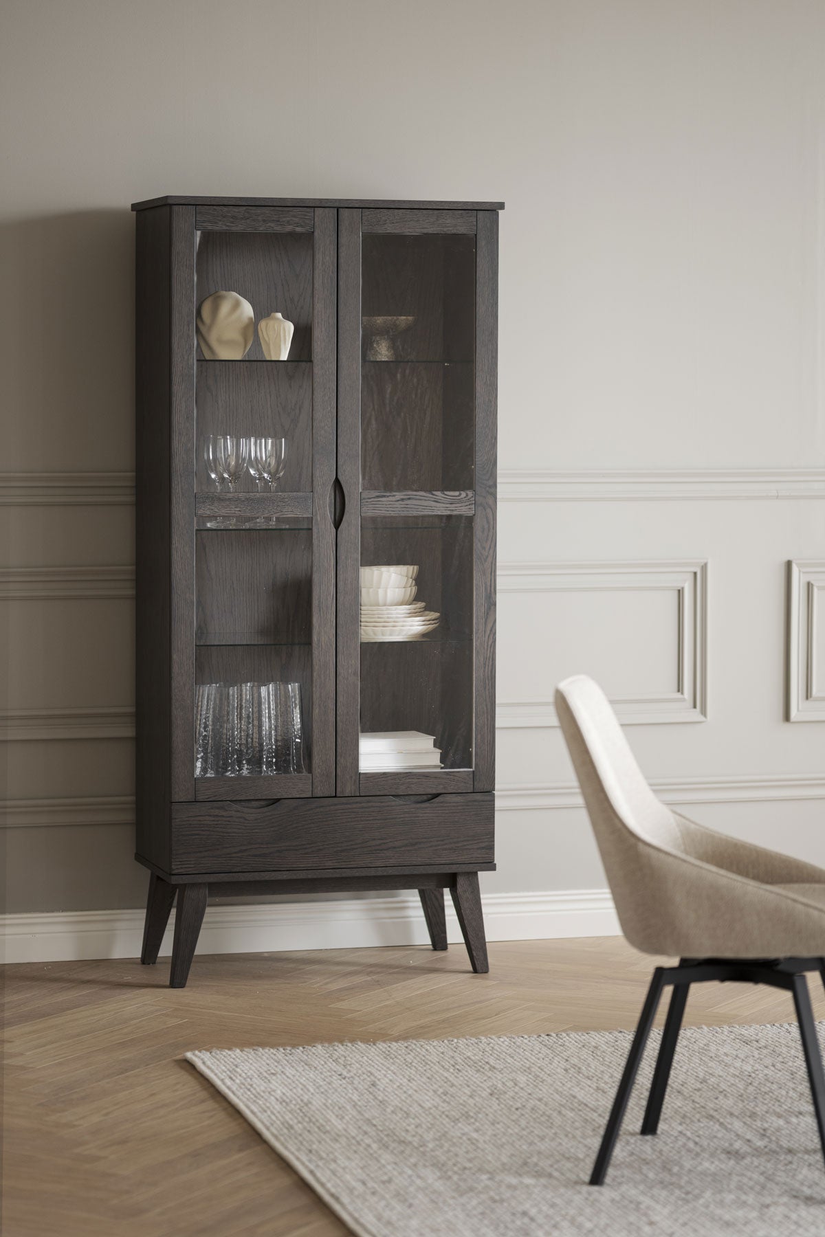 Filippa Vitrinskåp i mörkbrun ek fyllt med porslin och keramik