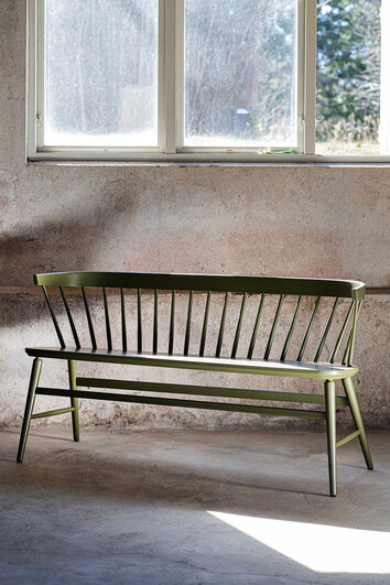Florida Pinnsoffa i Wigellsgrön lack i ett rum med rå betongvägg och ett fönster som släpper in dagsljus