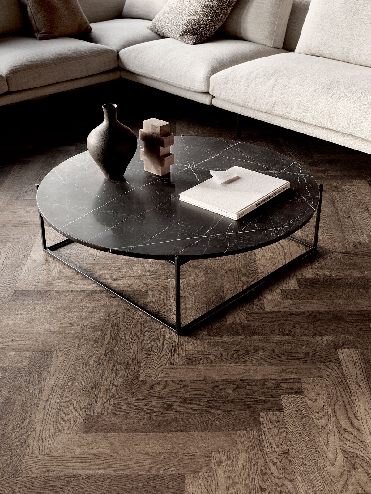 Circle Soffbord Ø100 i Svart Marmor i ett vardagsrum med mörkt trägolv.