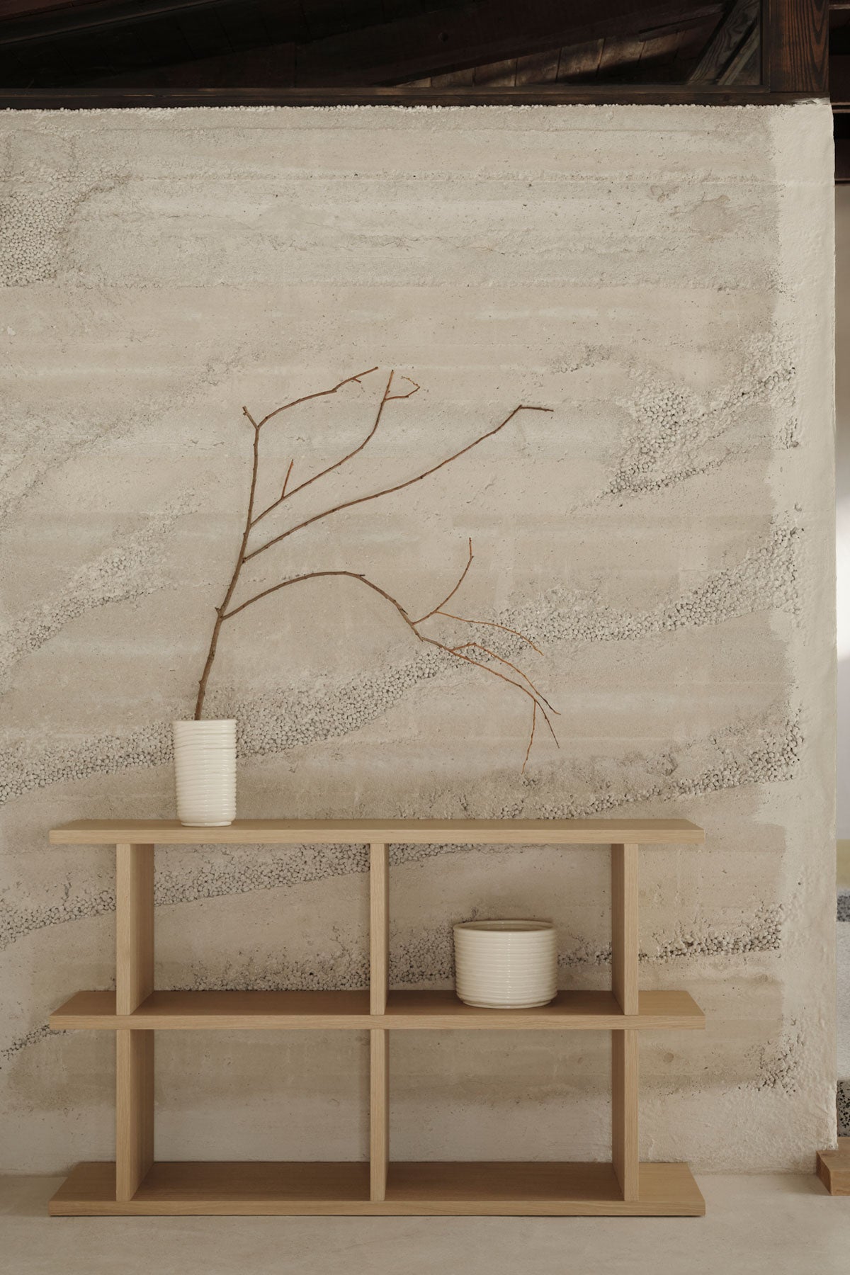 Kona 2x2 i färgen Natural ståendes mot vägg fylld med dekorationer.