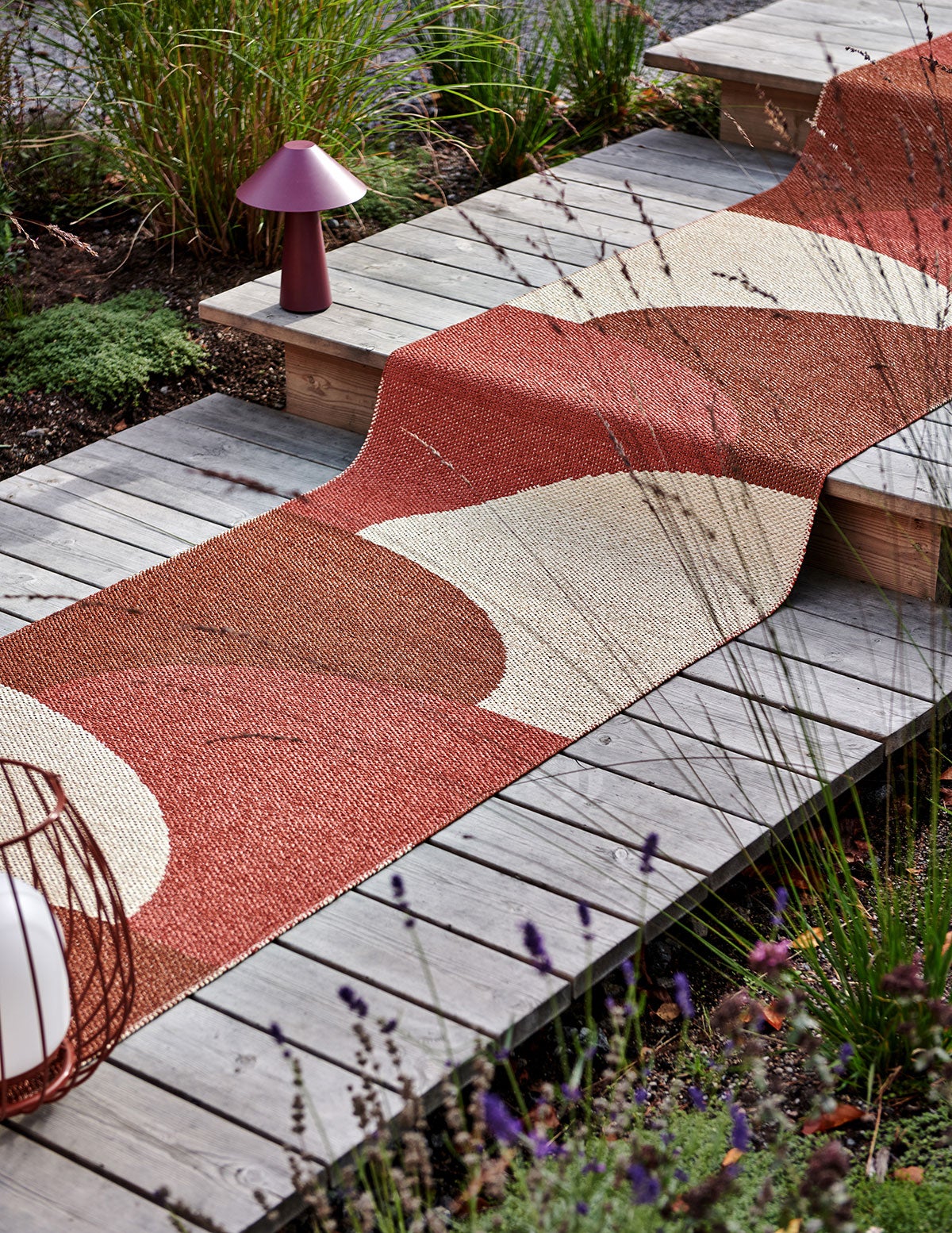 Hill Gångmatta i färgen Brick/Rust på trappa i trä utomhus