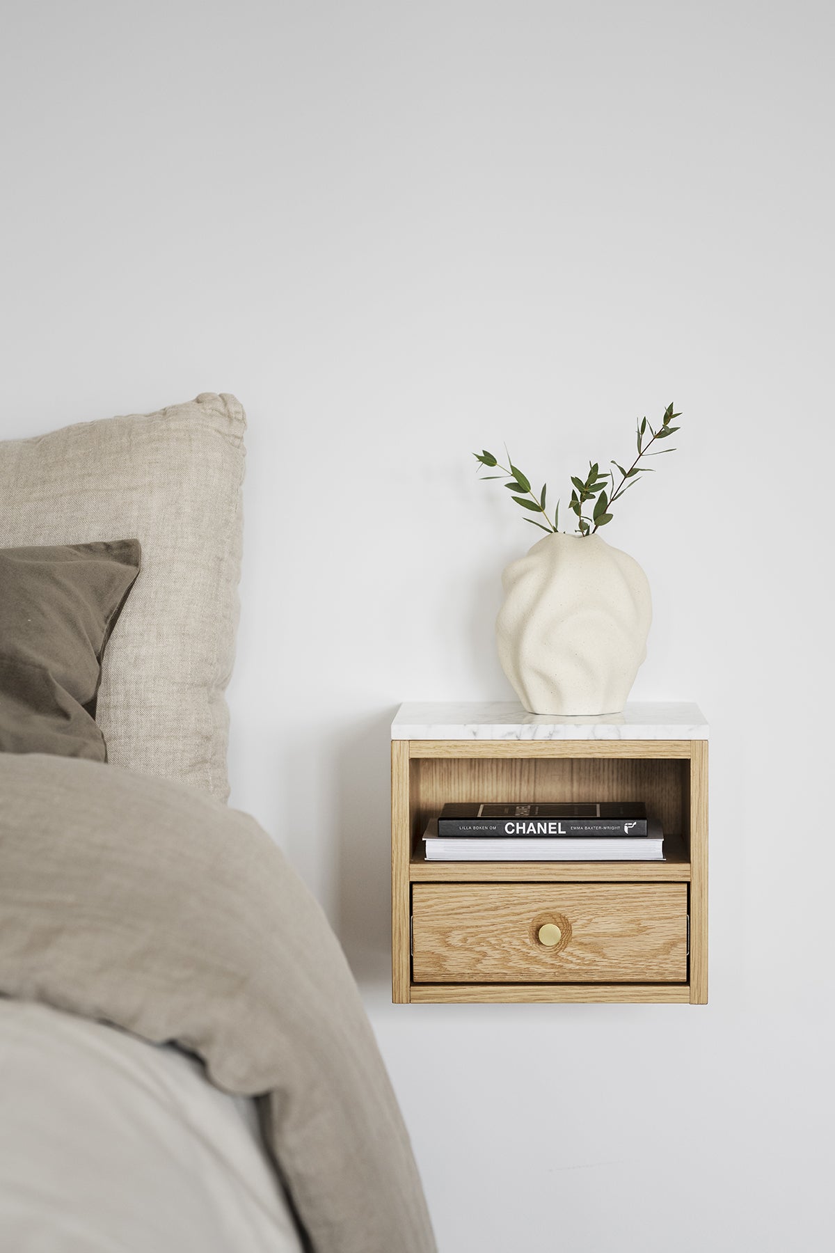 Whitmore Sängbord Ek bredvid bäddad säng i sovrum