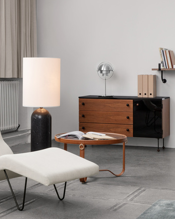 Adnet Soffbord bredvid golvlampa med ett sideboard i bakgrunden