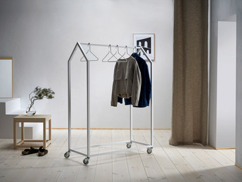 Clothing House Klädställning där det hänger två jackor på i en  minimalistisk hall.
