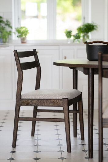 Kerwin Stol i brun ek med ljusbeige tyg vid runt matbord i kök