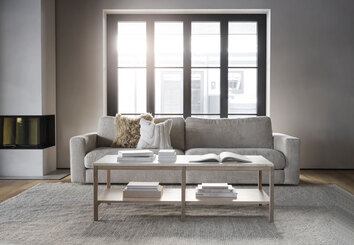  Orwel Soffbord Vitpigmenterad Ek / Travertin framför grå soffa