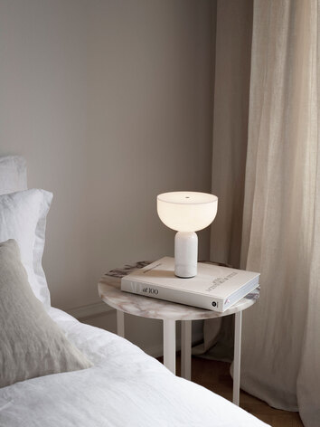 Kizu Portabel Bordslampa i vit marmor på sängbord bredvid bäddad säng