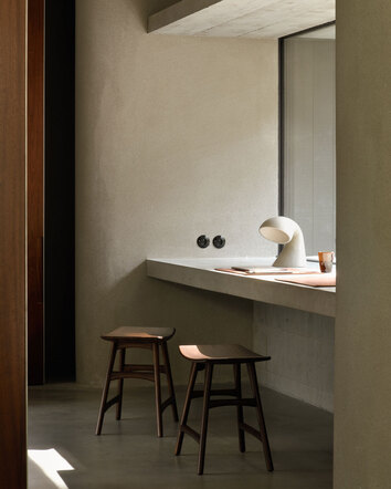 Osso pallar i brunlackad Teak ståendes i ett rum